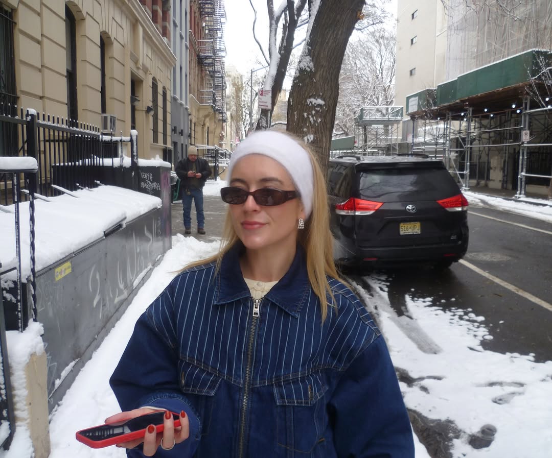 Person wearing sunglasses and a blue jacket on a snowy street with a car and building in the background wearing the Vienna Earrings in silver