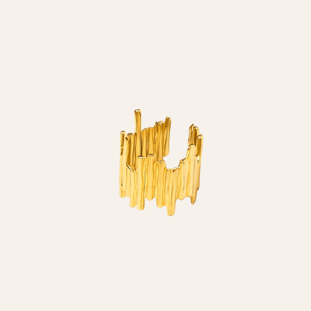 Gold ring with a modern, abstract design on a beige background