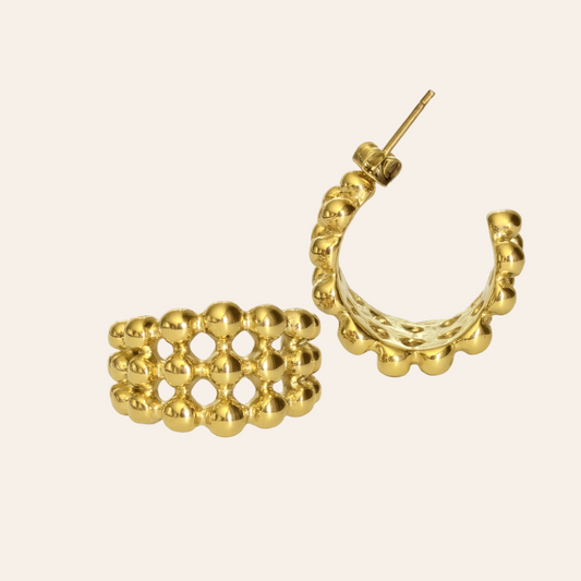 Gold hoop earrings with a textured design on a beige background - Vienna Earrings