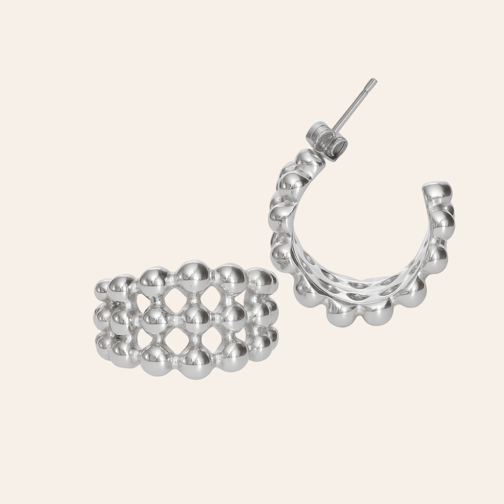 Silver hoop earrings with a unique design on a light beige background vienna earrings